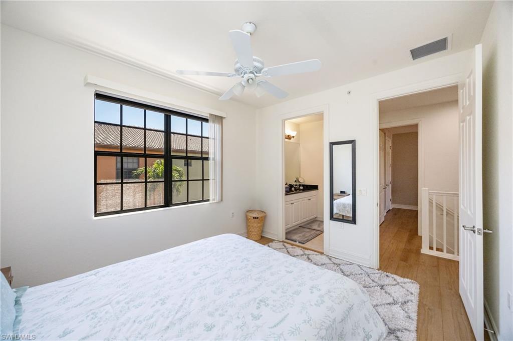 9128 Delano Street, Unit 892 Naples, FL 34113 - Photo 20 of 49 a bedroom with a large bed and a chandelier