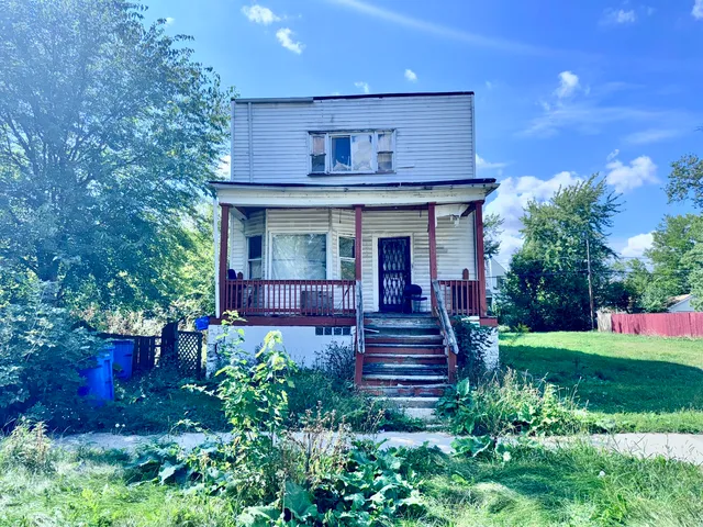 a view of a house with table and chairs in a yard