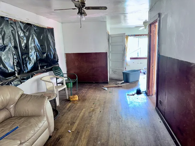a living room with furniture floor to ceiling window and wooden floor