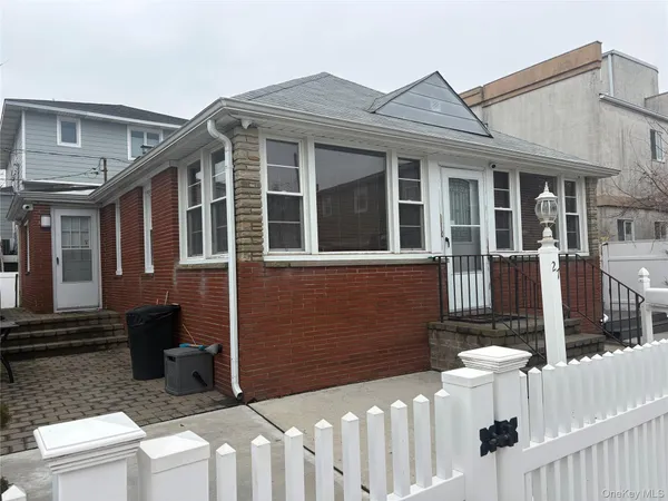 a view of a house with wooden fence and two windows