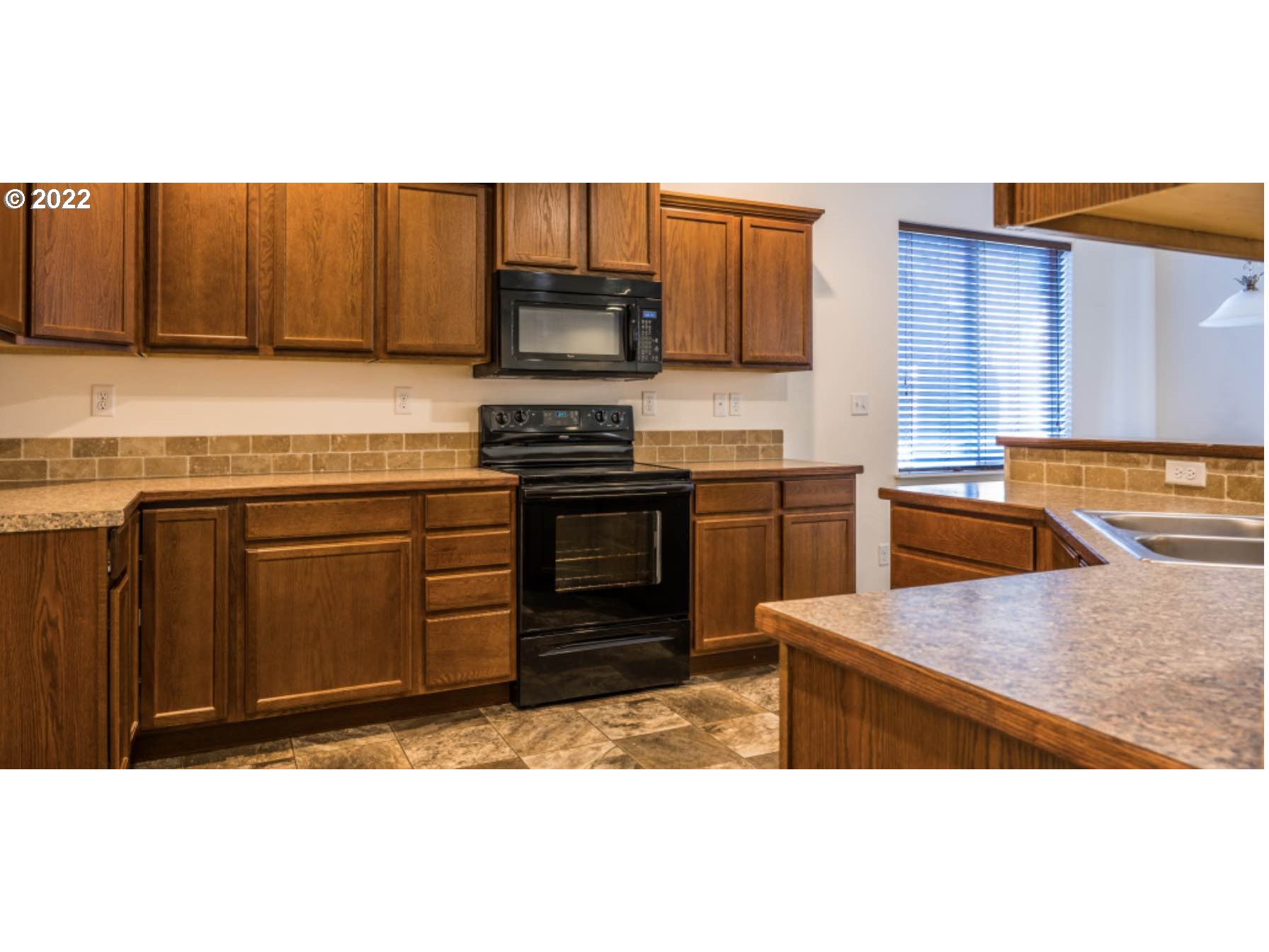 4902 Holly Street Springfield, OR 97478 - Photo 8 of 16 a kitchen with stainless steel appliances granite countertop a stove a sink and a microwave