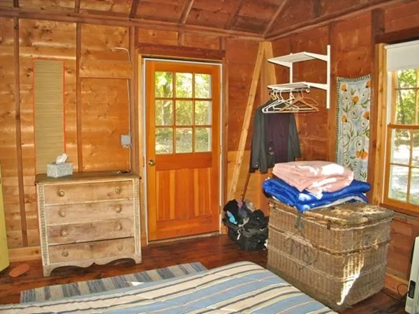 a view of a bedroom with a bed and wooden floor