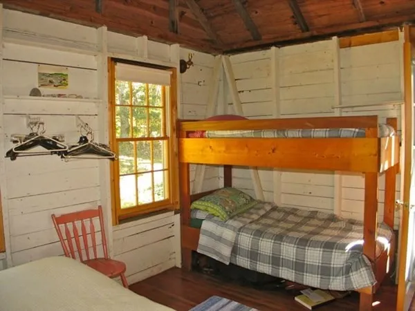 a bedroom with a bed and painting on the wall
