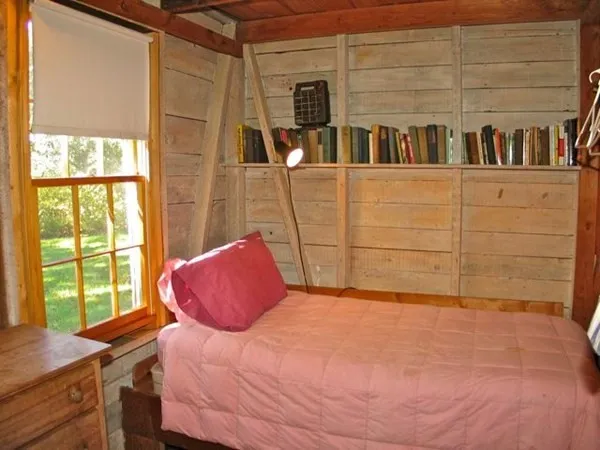 a bedroom with a bed and a book shelf