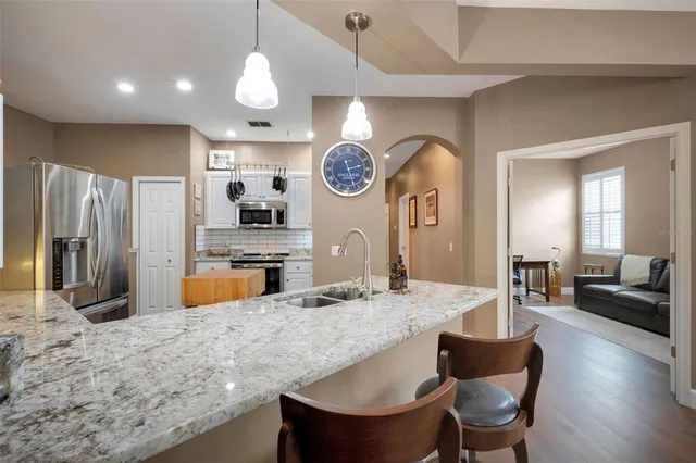a kitchen with stainless steel appliances granite countertop a sink a microwave cabinets and a dining table