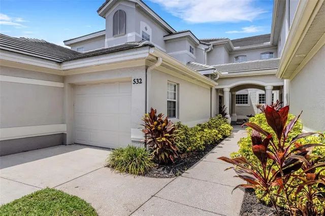a vase of flowers sitting on a table with floor to ceiling window