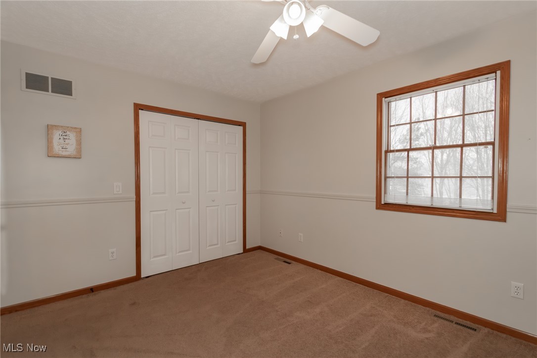 4815 South Ridge Road Perry, OH 44081 - Photo 26 of 48 Unfurnished bedroom featuring a closet, carpet floors, and ceiling fan