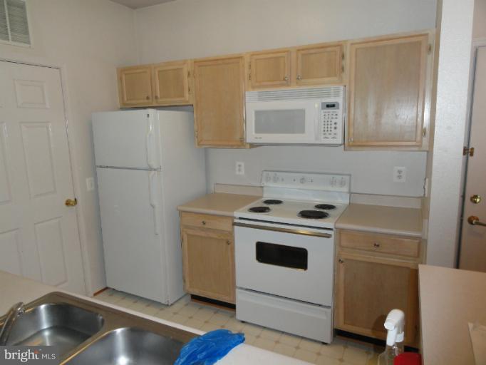 1600 Spring Gate Dr., Unit 2113 McLean, VA 22102 - Photo 5 of 6 a kitchen with a stove and a refrigerator