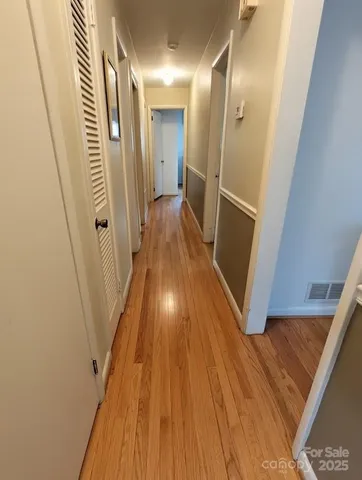 a living room with furniture a flat screen tv and kitchen view