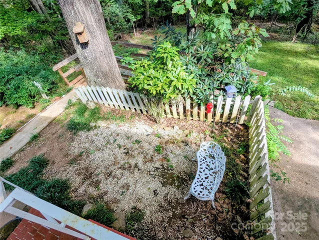 a view of a yard with wooden fence and a bench
