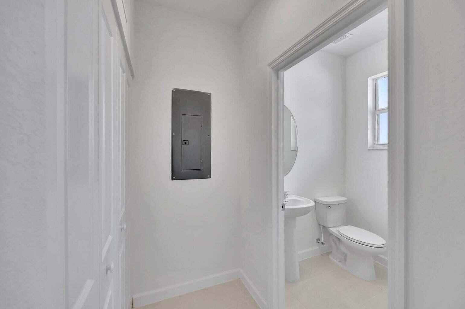 29190 Southwest 163rd Court Homestead, FL 33033 - Photo 5 of 15 a white toilet sitting next to a bathroom sink and vanity