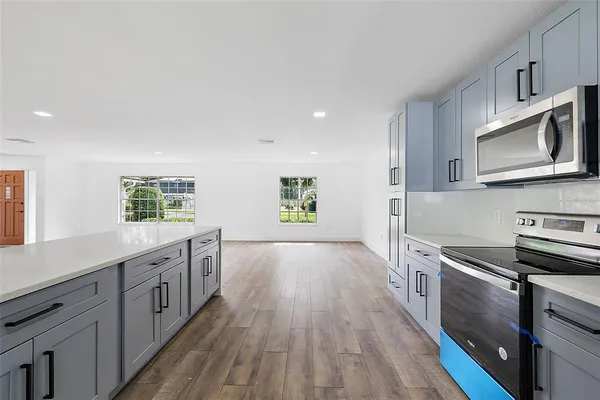 a kitchen with stainless steel appliances granite countertop a stove a sink and a microwave