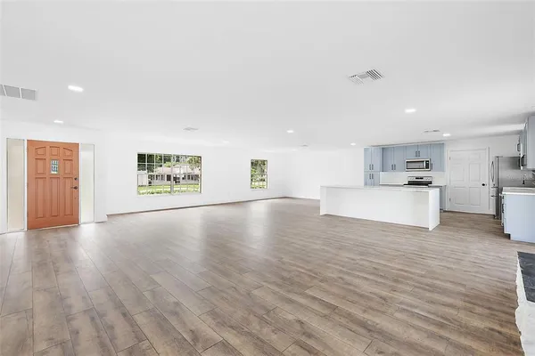 a view of a kitchen with furniture and wooden floor