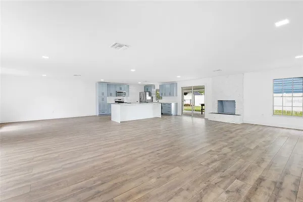 a view of a kitchen with furniture and wooden floor
