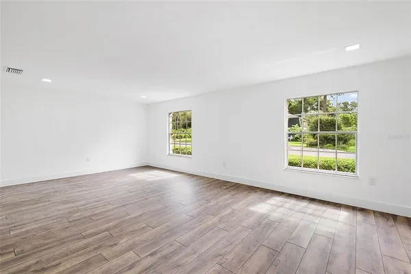 an empty room with wooden floor and window