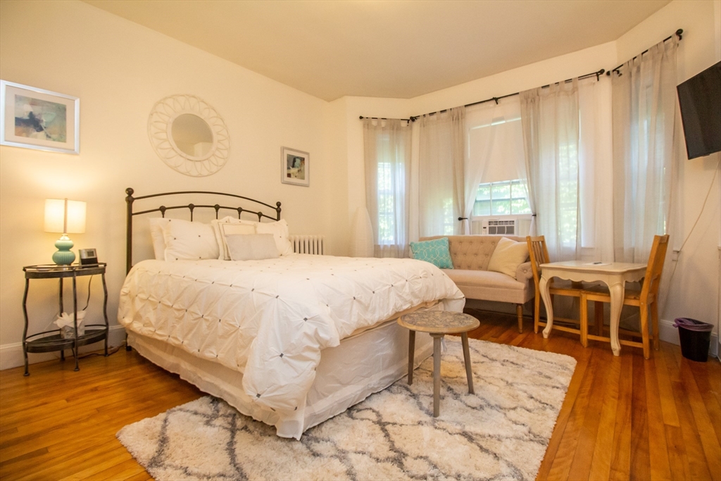 1253 Beacon Street, Unit C4 Brookline, MA 02446 - Photo 1 of 10 a bed room with a bed and a chair