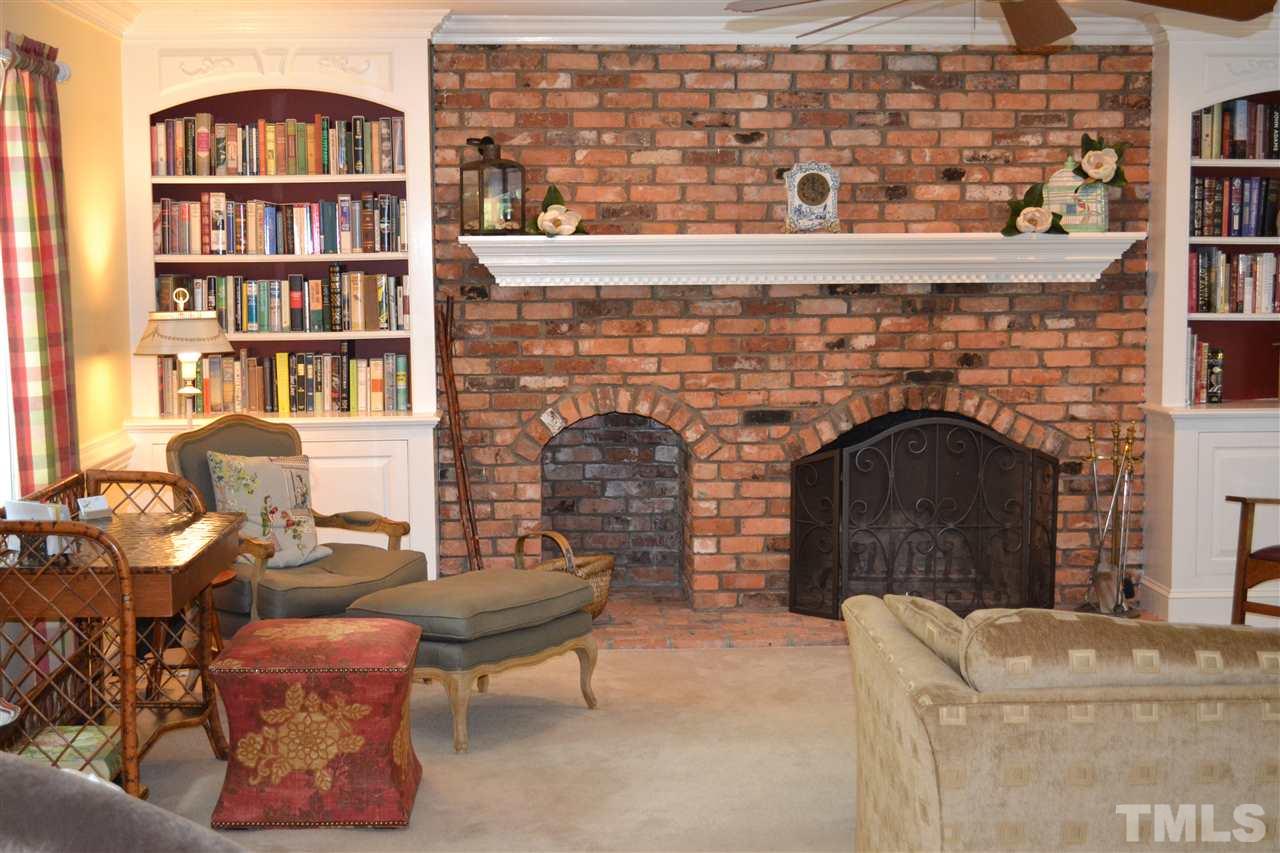 2320 Pastille Lane Raleigh, NC 27612 - Photo 7 of 25 a living room with furniture a fireplace and a book shelf