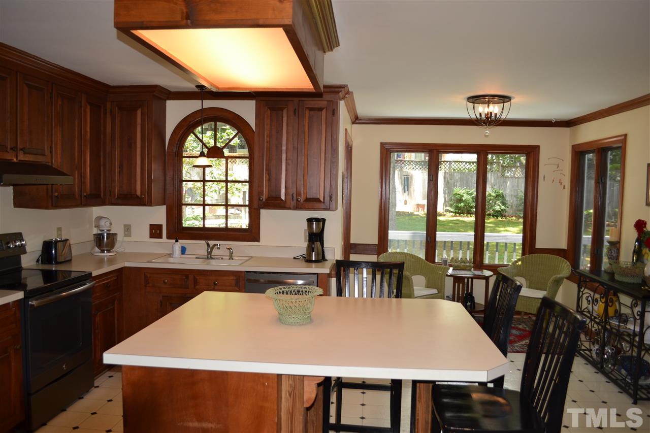 2320 Pastille Lane Raleigh, NC 27612 - Photo 8 of 25 a large kitchen with a table chairs and a refrigerator