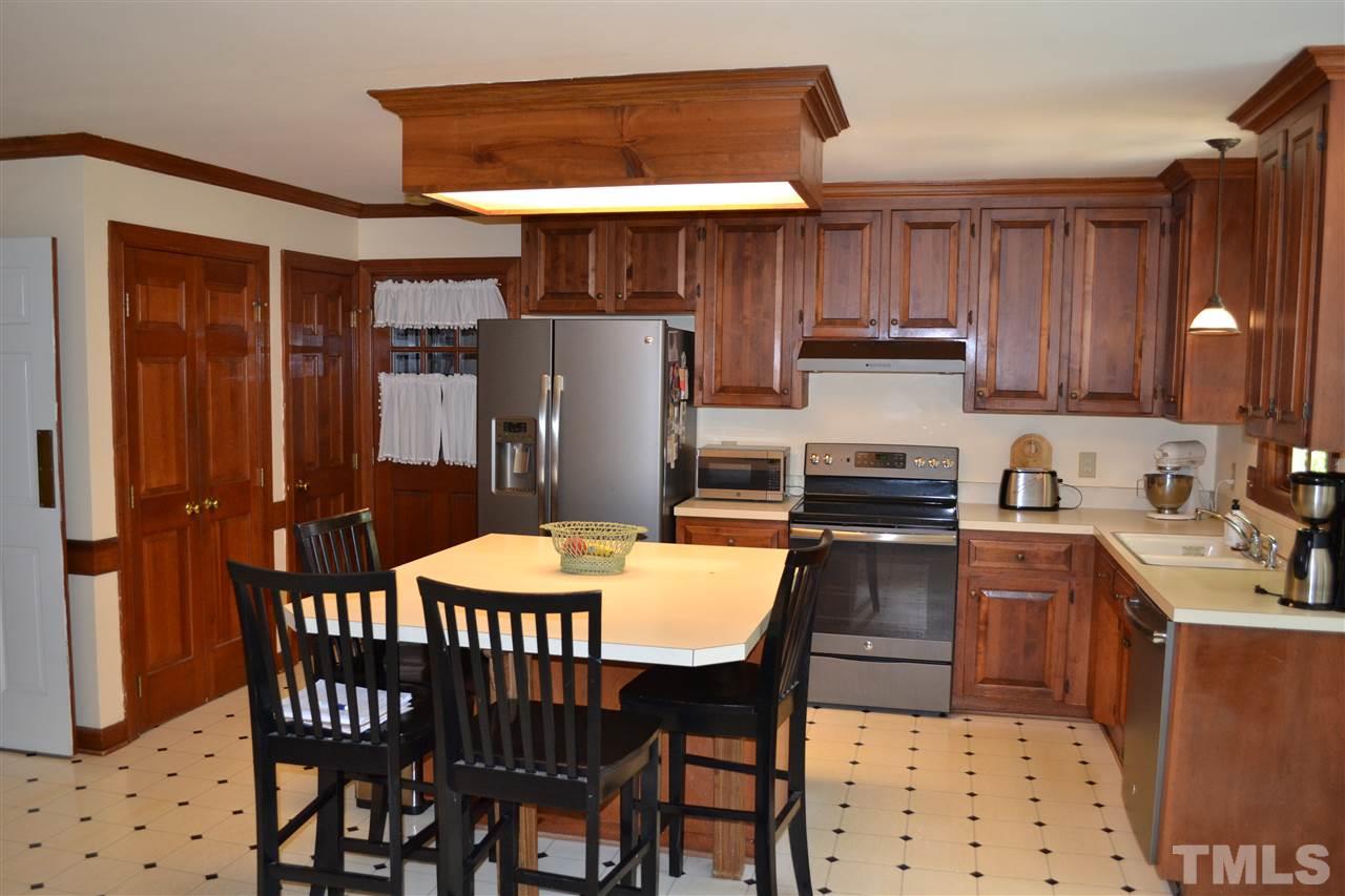 2320 Pastille Lane Raleigh, NC 27612 - Photo 10 of 25 a kitchen with stainless steel appliances wooden floor dining table and chairs