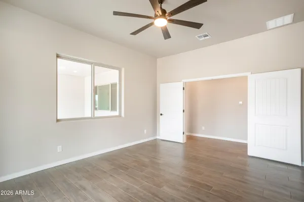 an empty room with wooden floor and windows