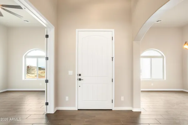 a view of empty room with window and wooden floor