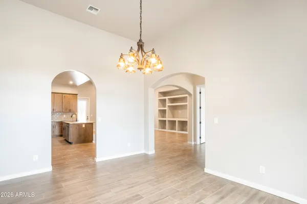 a view of a room with a chandelier and wooden floor