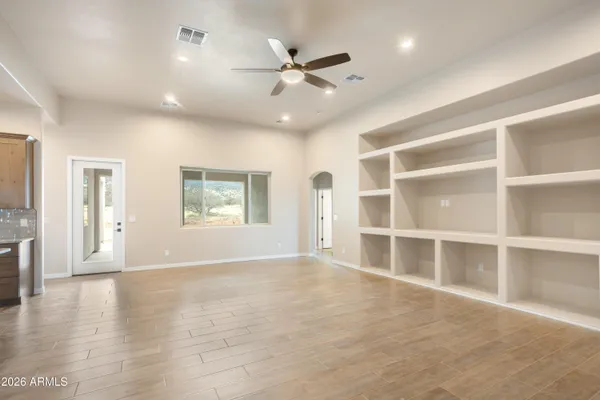 a view of an empty room with a window and a ceiling fan