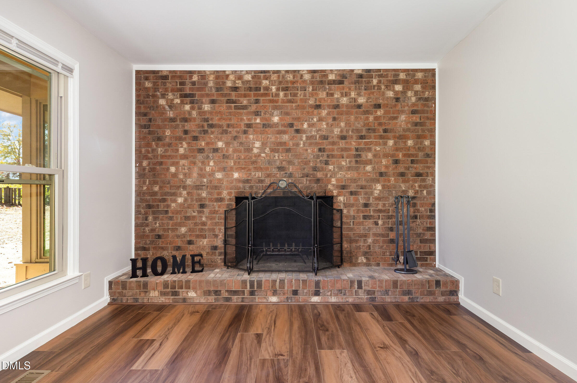 7020 Carpenter Fire Station Road Cary, NC 27519 - Photo 5 of 25 a view of empty room with a fireplace and wooden floor