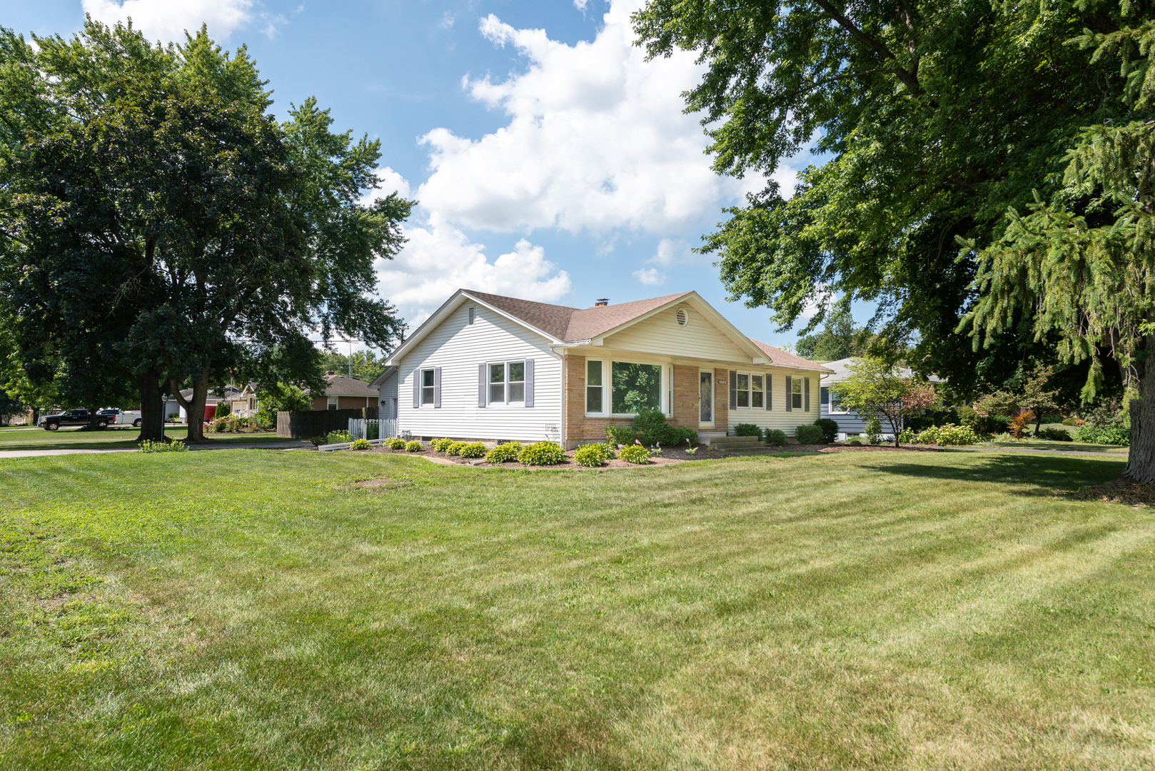 a front view of a house with a yard and trees