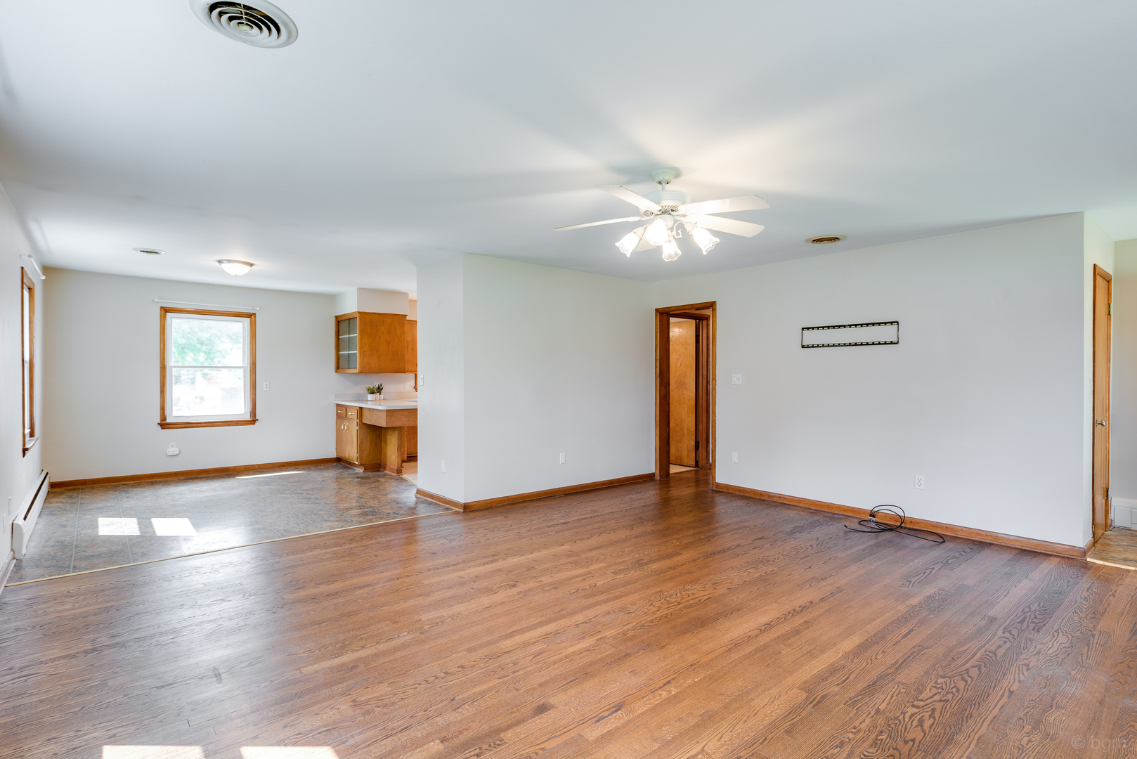 2232 Prairie Street Aurora, IL 60506 - Photo 5 of 28 an empty room with wooden floor chandelier fan and windows