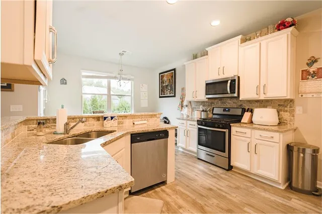a kitchen with stainless steel appliances granite countertop a sink stove and refrigerator
