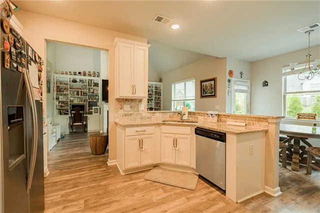 a kitchen with stainless steel appliances kitchen island granite countertop a refrigerator and a stove top oven