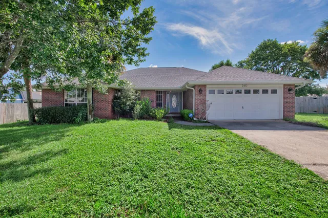 a view of a house with a yard and potted plants