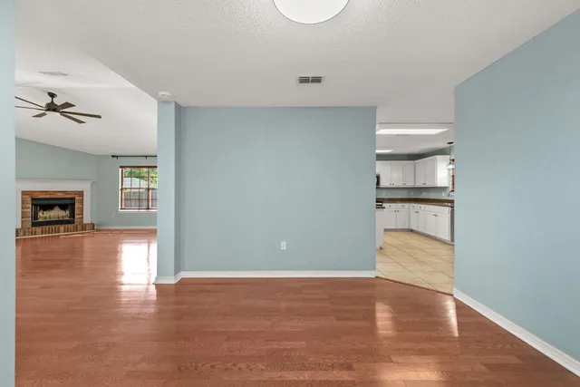 a view of empty room with wooden floor and fireplace