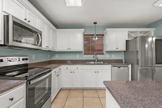 a kitchen with stainless steel appliances granite countertop a sink stove and cabinets