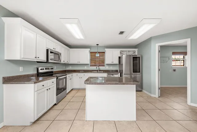 a kitchen with stainless steel appliances granite countertop a refrigerator and a stove