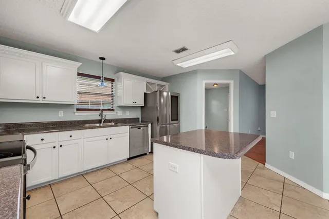 a kitchen with granite countertop a sink stainless steel appliances and cabinets