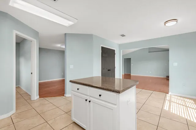 a kitchen with granite countertop a sink and white cabinets