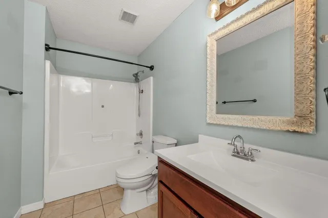 a bathroom with a sink a toilet and shower a mirror