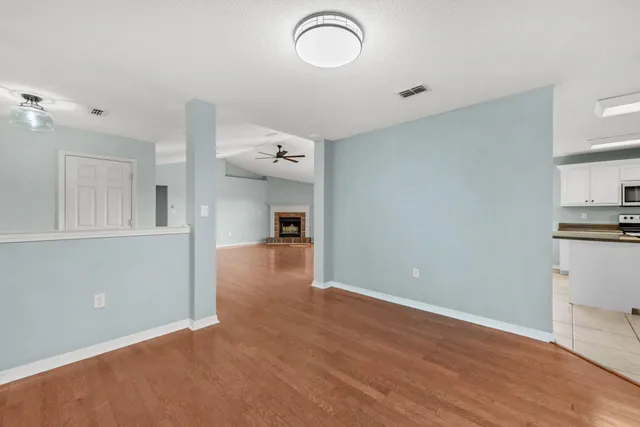 a view of a room with wooden floor and cabinets