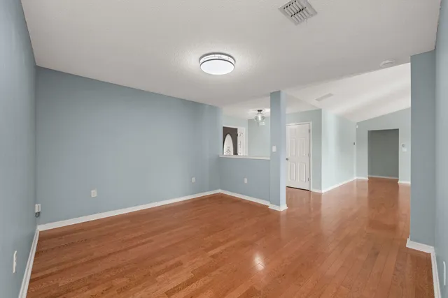 a view of empty room with wooden floor
