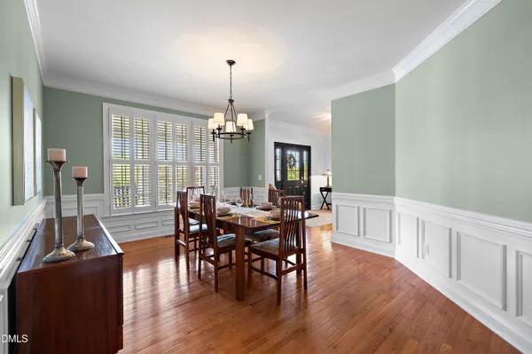 a kitchen with stainless steel appliances granite countertop a refrigerator a sink dishwasher a stove and white cabinets with wooden floor