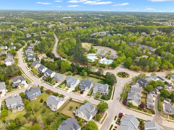 an aerial view of residential houses with yard and mountain view in back