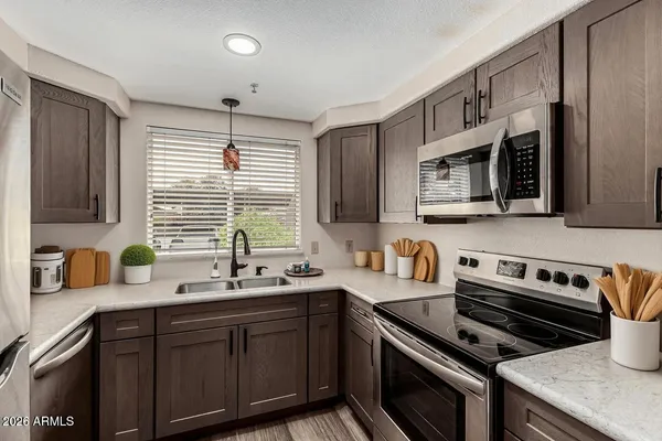 a kitchen with stainless steel appliances a sink stove and microwave