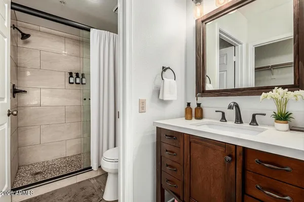 a bathroom with a granite countertop sink a toilet and shower