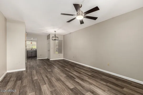 an empty room with wooden floor and a ceiling fan