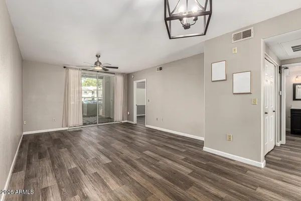 a view of an empty room and window with wooden floor