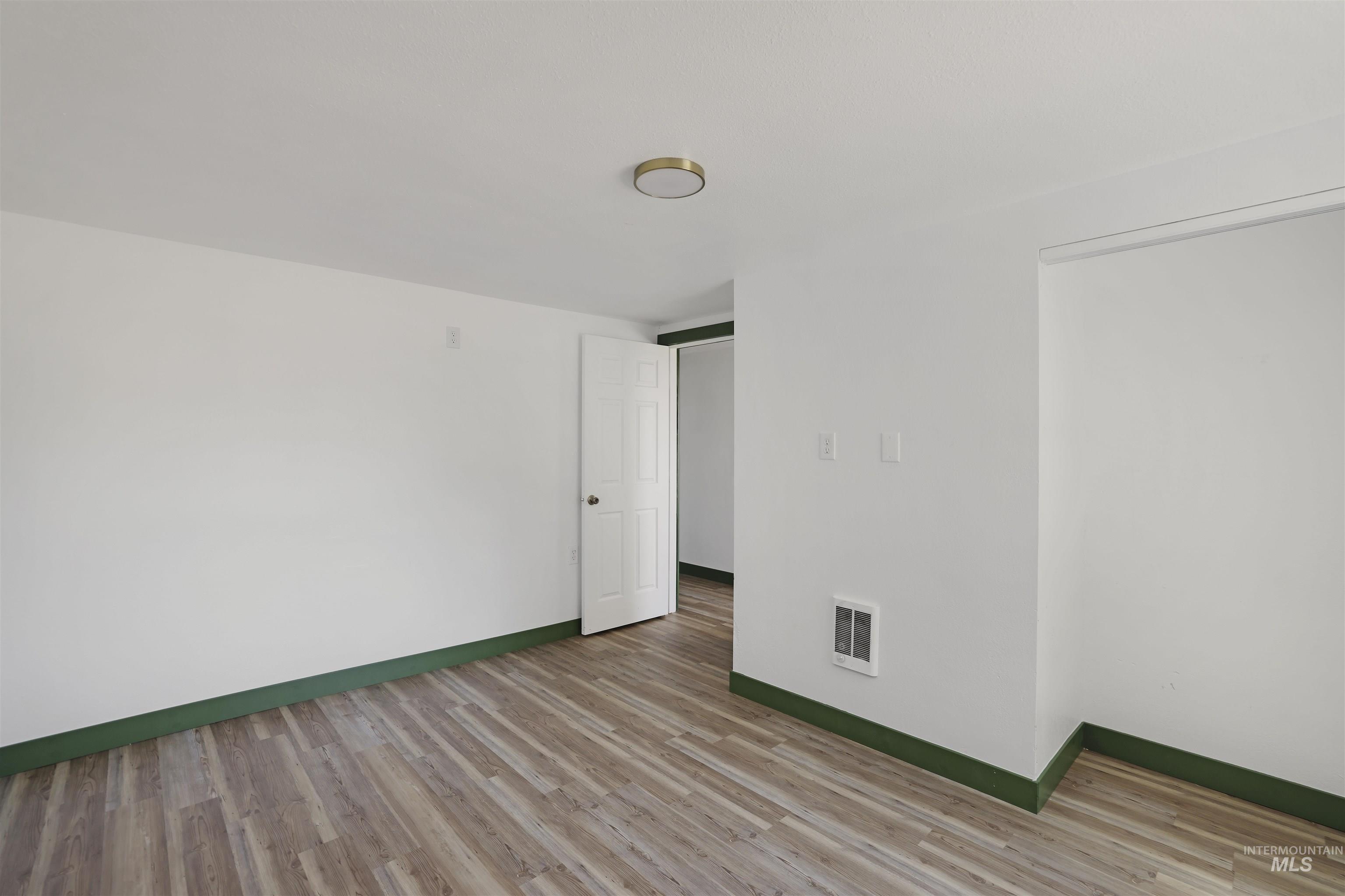 102 South 400 West Rupert, ID 83350 - Photo 9 of 15 Unfurnished room featuring light wood-type flooring and baseboards