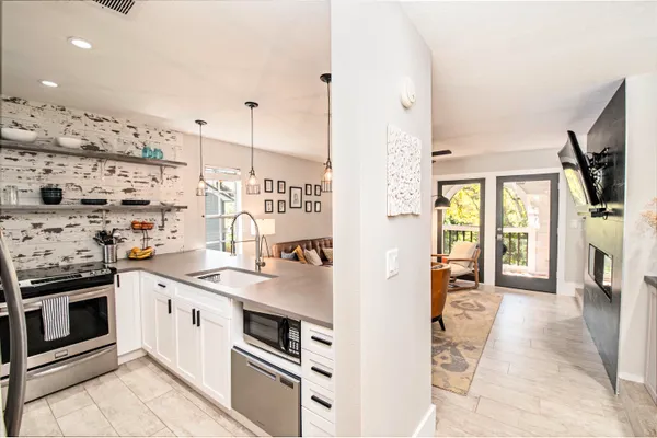a kitchen with stainless steel appliances kitchen island granite countertop a stove and a sink