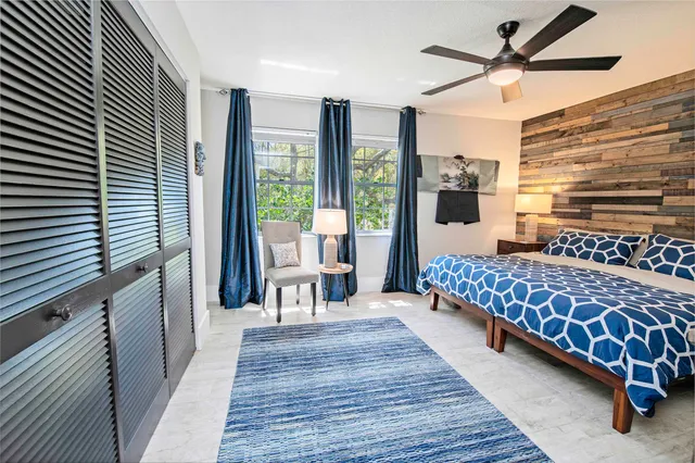 a bedroom with a bed and large windows